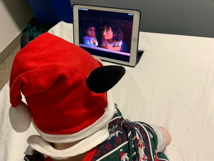 Un menor ingresado en el hospital Juan Ramón Jiménez viendo la película 'Encanto'.