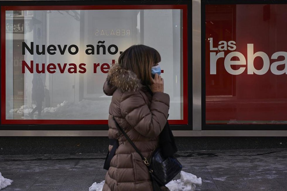 Archivo - Una persona pasa por delante de un establecimiento durante el séptimo día de las rebajas de invierno