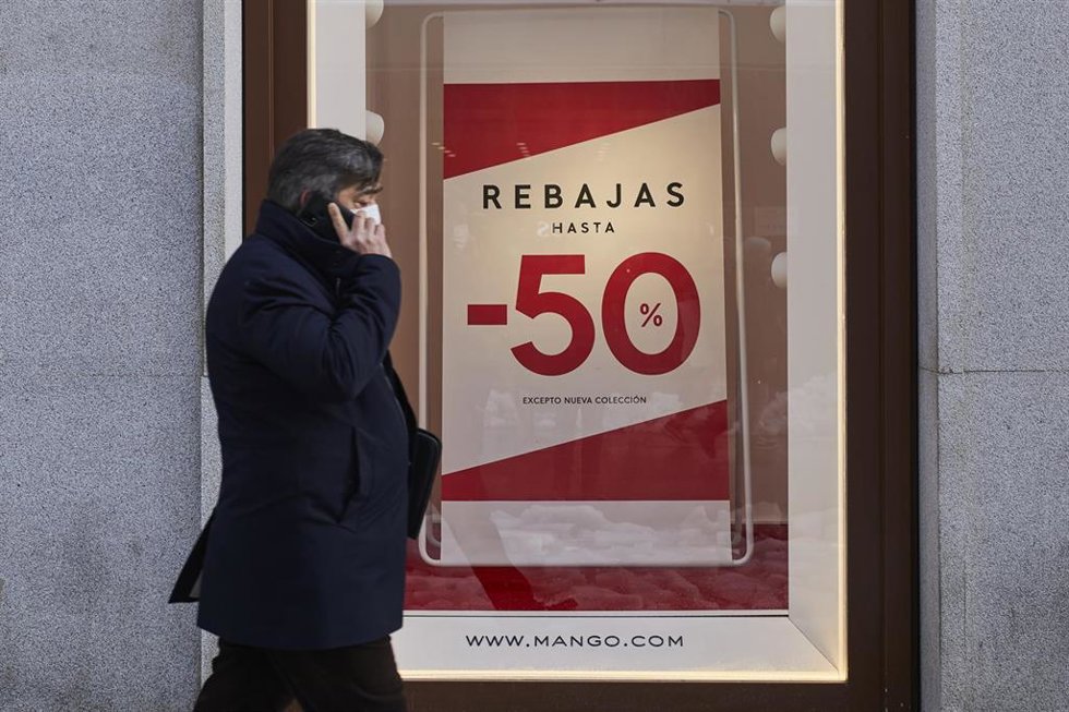 Archivo - Una persona pasa por delante de un establecimiento durante  las rebajas de enero (imagen de archivo)