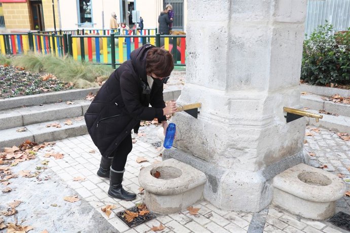 María Sánchez llena una botella de agua en la fuente del Caño Argales.
