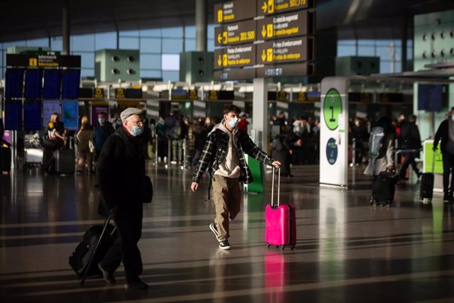 Archivo - Varios pasajeros con maletas en el aeropuerto de El Prat