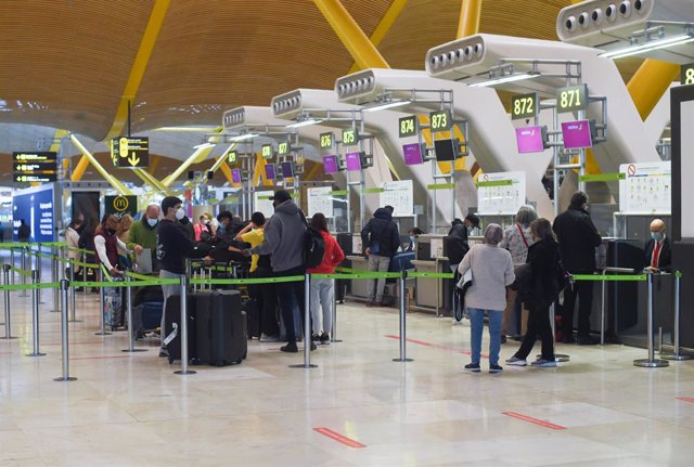 Varias personas facturan en el aeropuerto de Adolfo Suárez, un día previo a la Nochebuena, a 23 de diciembre de 2021, en Madrid (España).