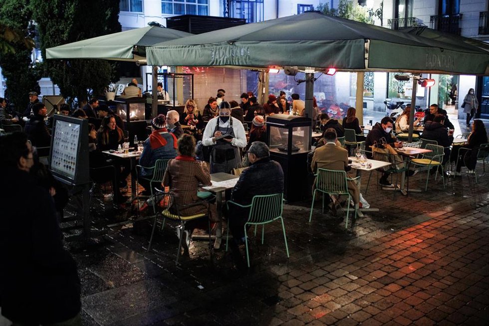 Varias personas toman el aperitivo en la Plaza de Santa Ana para celebrar la llegada de la Nochebuena