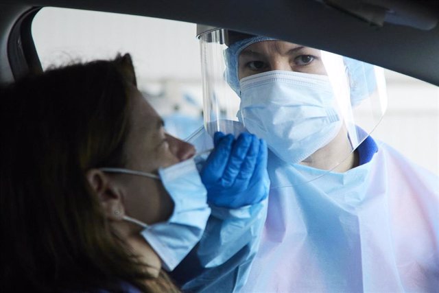 Una sanitaria le realiza la prueba PCR a una mujer en su coche durante la realización de PCR en el autocovid instalado en el Hospital Militar, a 28 de diciembre de 2021 en Sevilla (Andalucía, España)