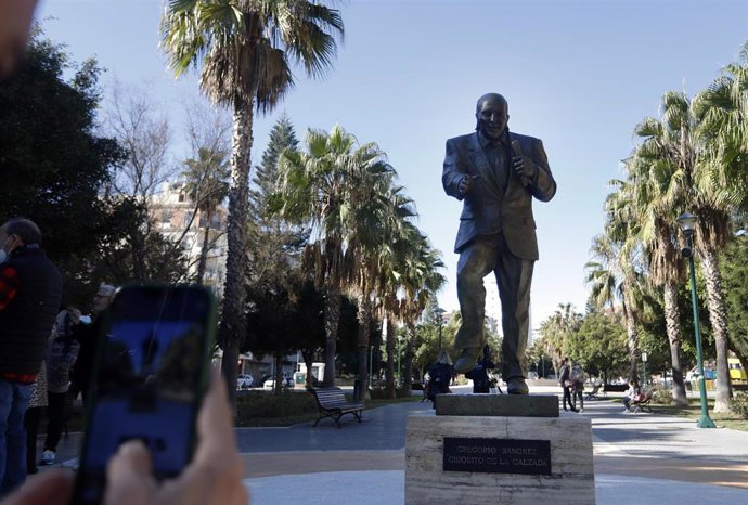 Varias personas se acercan y se hacen fotos con  la nueva escultura al humorista malagueño Gregorio Sánchez, Chiquito de la Calzada, ubicada en el parque público que lleva su propio nombre