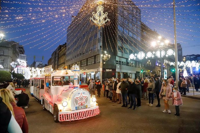 Un grupo de personas observa a un tren navideño, a 12 de diciembre de 2021, en Vigo, Galicia (España). 