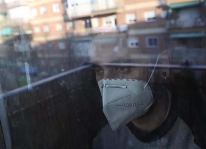 Una persona con mascarilla en su domicilio.