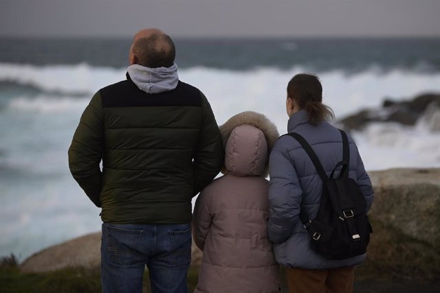 Tres personas observan el fuerte oleaje como consecuencia de la borrasca Barra, a 7 de diciembre de 2021, en A Coruña, Galicia (España). Galicia termina el puente de la Constitución en alerta naranja por la entrada de la borrasca Barra, que dejará fuertes