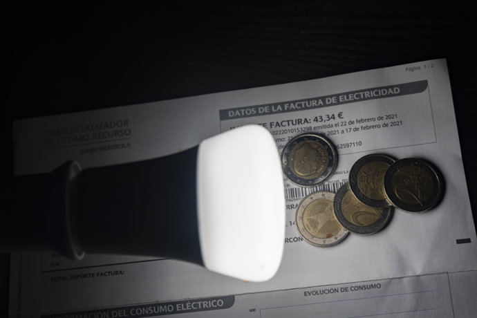 Una lámpara refleja el importe de una factura el día en que el precio de la luz ha marcado un mínimo por primera vez en dos meses, a 27 de diciembre de 2021, en Madrid, (España). 