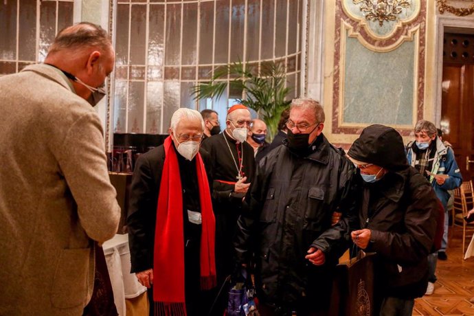 El Padre Ángel (i)  durante el reparto de una bolsa con la tradicional cena de Nochebuena para personas sin hogar, organizada por Mensajeros de la Paz, en el Real Casino de Madrid, a 24 de diciembre de 2021, en Madrid 