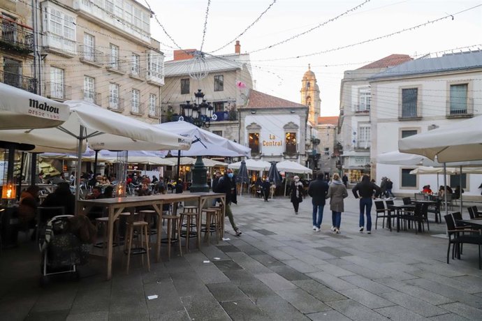 Un grupo de personas pasea por las calles tras varios días de lluvia, a 12 de diciembre de 2021, en Vigo, Galicia (España). 
