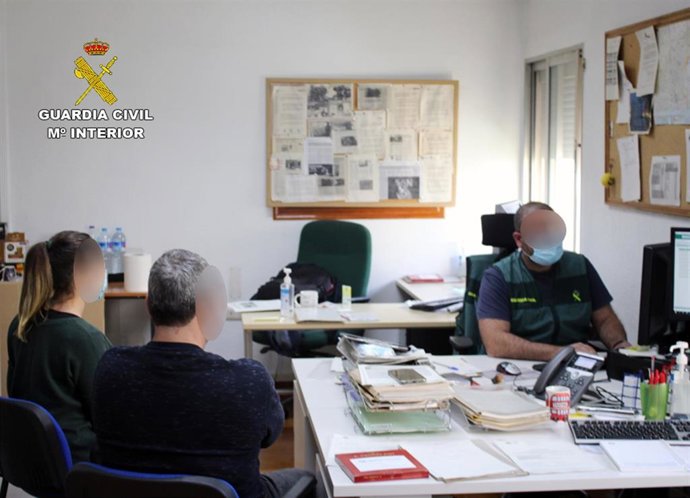 Agente de la Guardia Civil toma declaración a dos personas