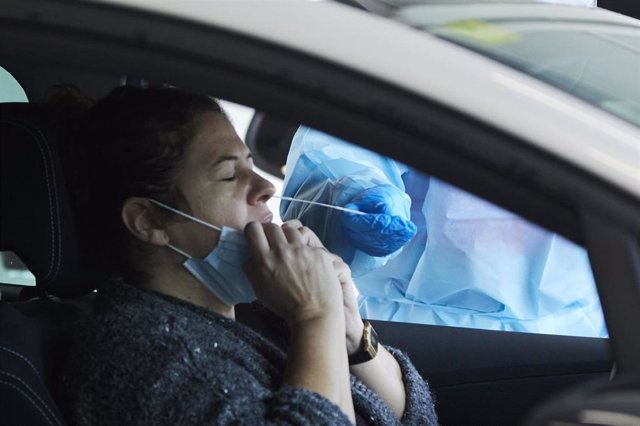 Una sanitaria le realiza la prueba PCR a una mujer en su coche durante la realización de PCR en el autocovid instalado en el Hospital Militar, a 28 de diciembre de 2021 en Sevilla (Andalucía, España)