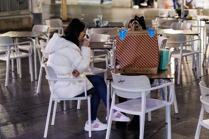 Dos amigas toman el aperitivo en la calle Montera para celebrar la llegada de la Nochebuena, a 24 de diciembre de 2021, en Madrid (España). A pesar de las nuevas restricciones, como el uso de la mascarilla en exteriores, que entra en vigor hoy, varias p