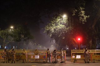 Un grupo de efectivos de la Policía hace guardia durante el toque de queda impuesto en Nueva Delhi para contener el avance del coronavirus.