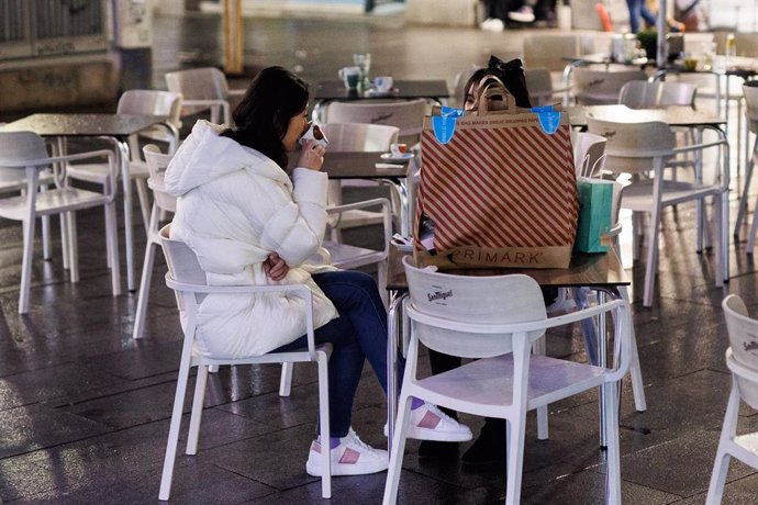 Dos amigas toman el aperitivo en la calle Montera para celebrar la llegada de la Nochebuena, a 24 de diciembre de 2021, en Madrid (España). A pesar de las nuevas restricciones, como el uso de la mascarilla en exteriores, que entra en vigor hoy, varias p