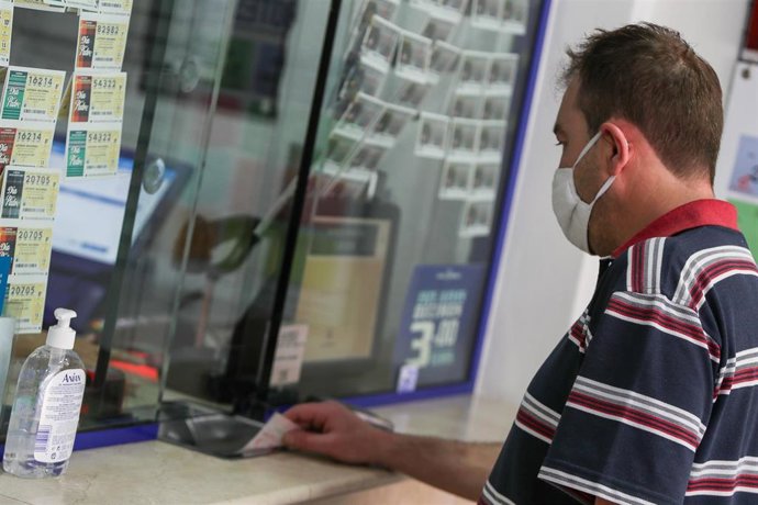 Archivo - Un hombre compra lotería en una Administración en Manises.