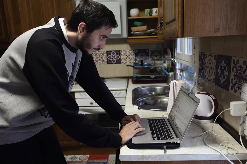 Una persona teletrabaja en la cocina de su domicilio