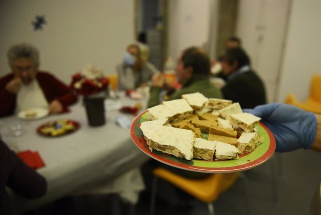 Un voluntario sostiene un plato para servir en el Fodar Do Transeunte, durante la noche de Fin de Año, a 31 de diciembre de 2021, en Ourense