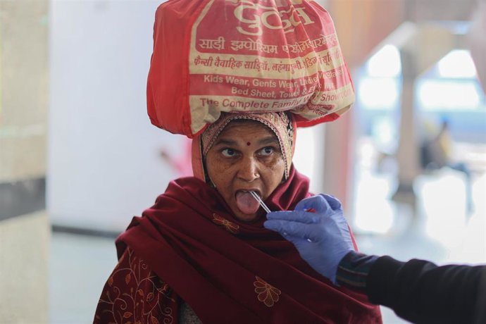01 January 2022, India, New Delhi: A healthcare worker collects a coronavirus (Covid-19) test swab sample from a woman amidst the spread of the disease, at a railway station. Photo: Karma Sonam Bhutia/ZUMA Press Wire/dpa