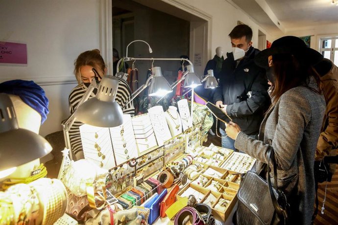 Una mujer se prueba bisutería en un puesto