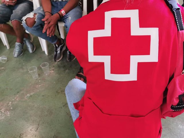 Archivo - Un voluntario de Cruz Roja atiende a personas llegadas en patera en Xàbia, en una imagen de archivo