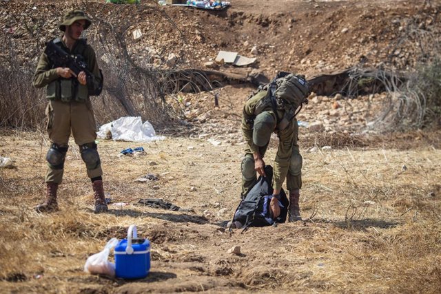 Archivo - 08 September 2021, Israel, Mukabli: Israeli soldiers checking Palestinian workers bags near a security fence where a massive manhunt is in progress to capture the six prisoners, who broke out of the high-security Gilboa Prison earlier this week.