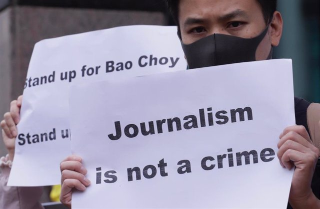 El periodista Choy Yuk Ling protesta con una pancarta.