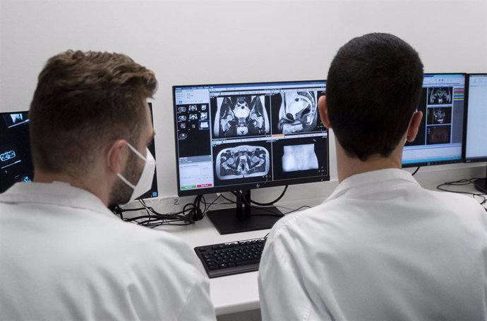 Dos técnicos controlan el único sistema de radioterapia de precisión molecular guiada por resonancia magnética que existe en España, en el Hospital Carlos III, a 17 de diciembre de 2021, en Madrid, (España). Estos técnicos controlan el aparato de radiot