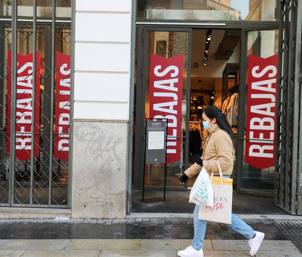 Archivo - Una mujer pasa por delante de un establecimiento durante el séptimo día de las rebajas de invierno, en Madrid, (España), a 15 de enero de 2021. Según indica la EAE Business, el sector de moda y complementos será el más afectado debido al impac