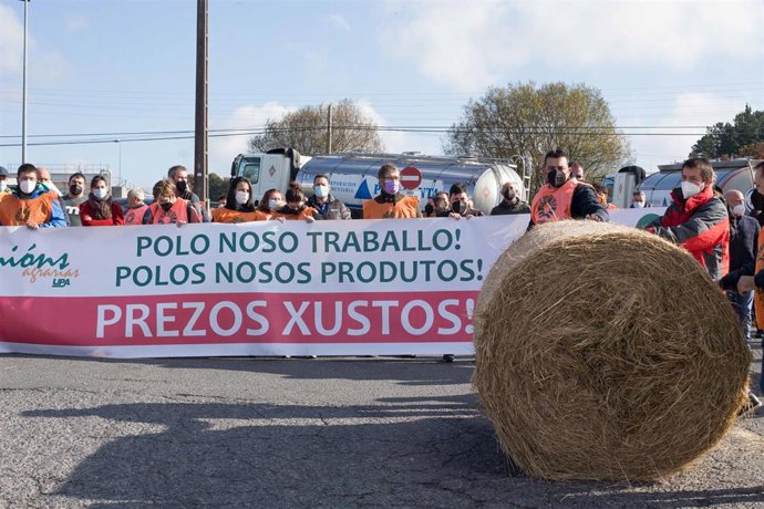 Archivo - Varias personas sujetan la pancarta principal de la manifestación en defensa de unos precios justos para la producción de leche, ante la planta de Larsa, a 16 de noviembre de 2021, en Robra, Outeiro de Rei, Lugo, Galicia, (España). Apoyados po