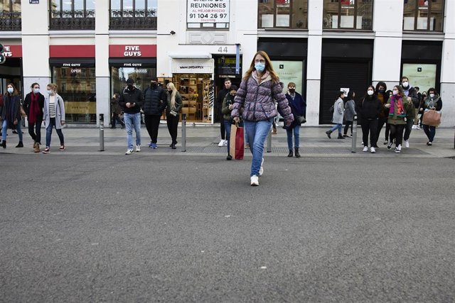 Varias personas con bolsas pasean en una calle comercial del centro de Madrid
