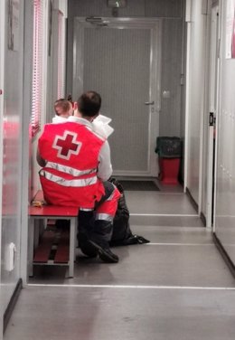 Archivo - Un voluntario de Cruz Roja atiende a personas llegadas en patera a Almería