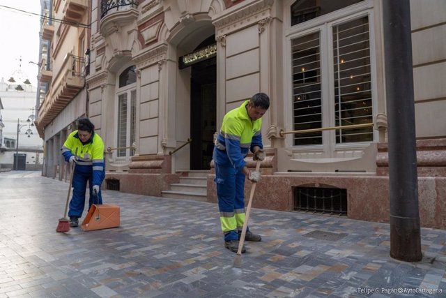 Archivo - Dis operarios trabajan en la limpieza de una calle