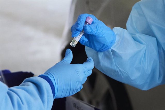 Una enfermera da una muestra de PCR para su análisis durante la realización de PCR en el autocovid instalado en el Hospital Militar, a 28 de diciembre de 2021 en Sevilla (Andalucía, España)