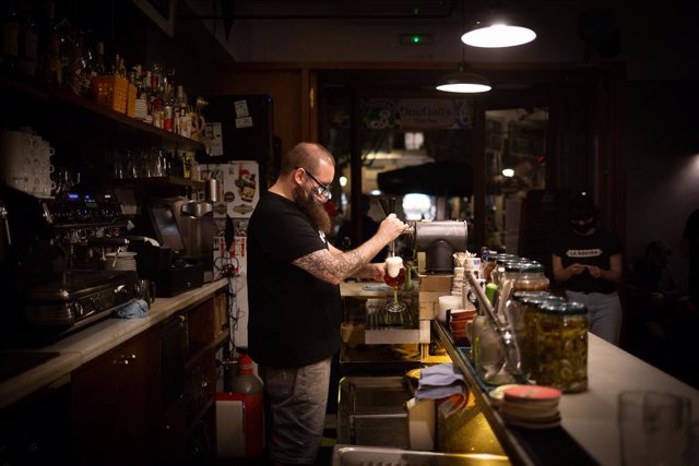 Archivo - Arxiu - Un cambrer serveix una cervesa a l'interior d'un bar de Barcelona