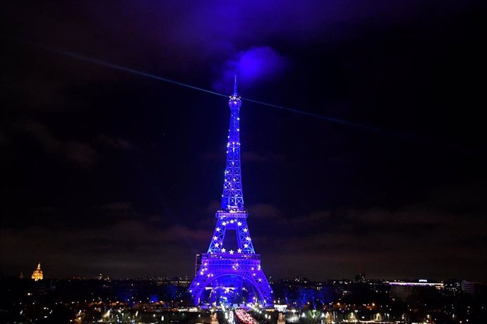 31 December 2021, France, Paris: The Eiffel Tower glows blue on New Year's Eve to mark the French presidency of the EU Council. Photo: Alain Jocard/AFP/dpa