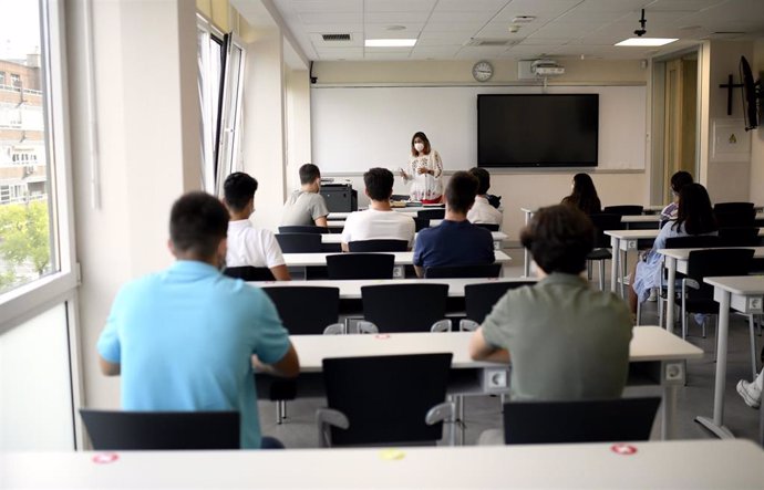 Archivo - Una profesora da clase con mascarilla a alumnos en la Facultad de Humanidades y Ciencia de la Comunicación de la Universidad privada CEU San Pablo durante el primer día del curso 2020-2021, en Madrid (España), a 14 de septiembre.  