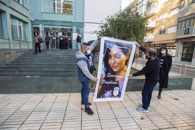 Dos familiares portan un cartel de la fallecida, frente a los juzgados de Cartagena