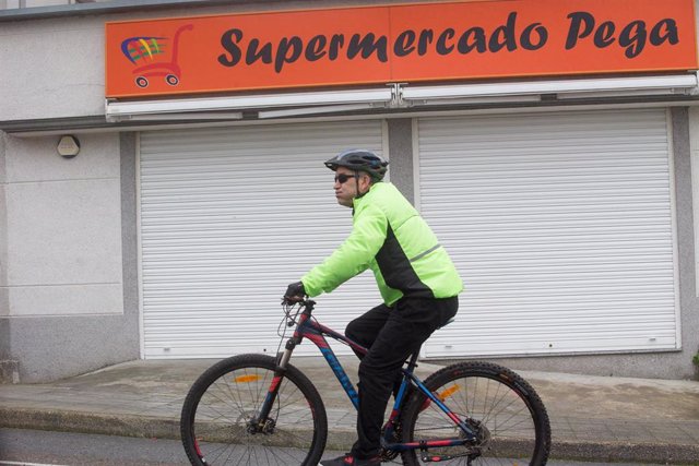 Archivo - Un ciclista pasa frente a un supermercado cerrado en Paraleda, Lugo, Galicia (España), a 19 de marzo de 2021. Este municipio junto a Maside y Vilardevós de la provincia de Ourense, están cerrados perimetralmente por encontrarse en el nivel máxim