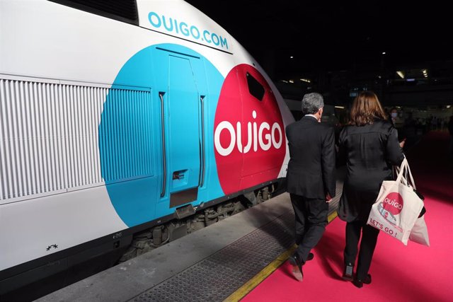Archivo - Dos personas caminan por el andén durante la inauguración del primer trayecto de Ouigo, a 7 de mayo de 2021, en Atocha, Madrid