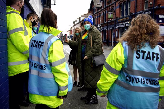 02 January 2022, United Kingdom, Liverpool: Everton fans have their passes check by covid-19 staff before the English Premier League soccer match between Everton and Brighton and Hove Albion at Goodison Park. Photo: Peter Byrne/PA Wire/dpa