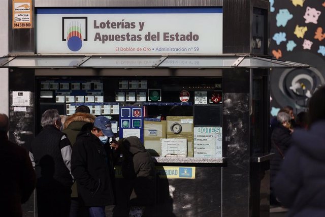Varias personas en las inmediaciones de la administración de loterías 'El doblón de oro', tres días antes del Sorteo de La Lotería del Niño, a 3 de enero de 2022, en Madrid, (España). 