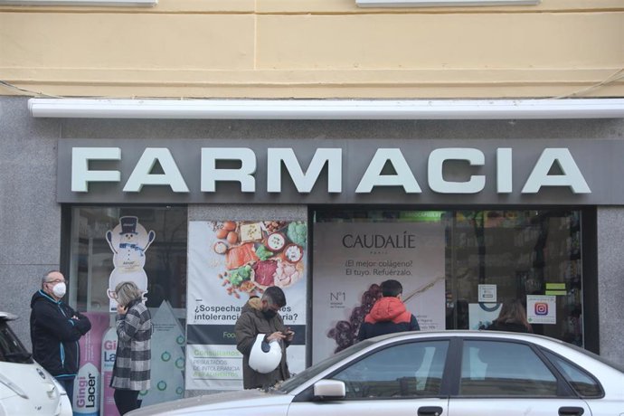 Varias personas hacen cola en una farmacia para adquirir un test de antígenos.