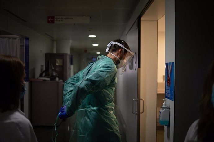 Archivo - Un médico entra en una de las habitaciones de una Unidad de Cuidados Intensivos de un hospital, foto de archivo 