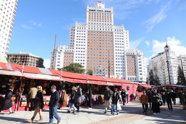 Varias personas pasean por el mercadillo La Navideña, situado en la plaza de España.