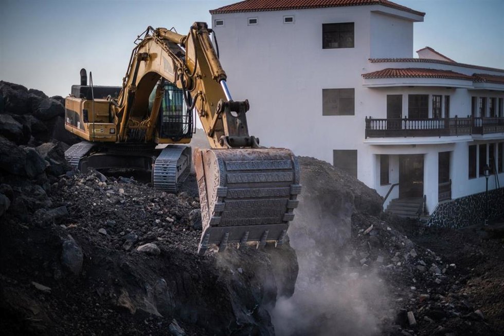 Una pala procede a la retirada de lava en el cruce de La Laguna, en el municipio de Los Llanos de Aridane, en la isla de La Palma, días después de darse por finalizada oficialmente la erupción del volcán