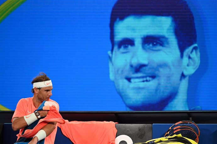 Archivo - Rafa Nadal, ante una imagen de Novak Djokovic