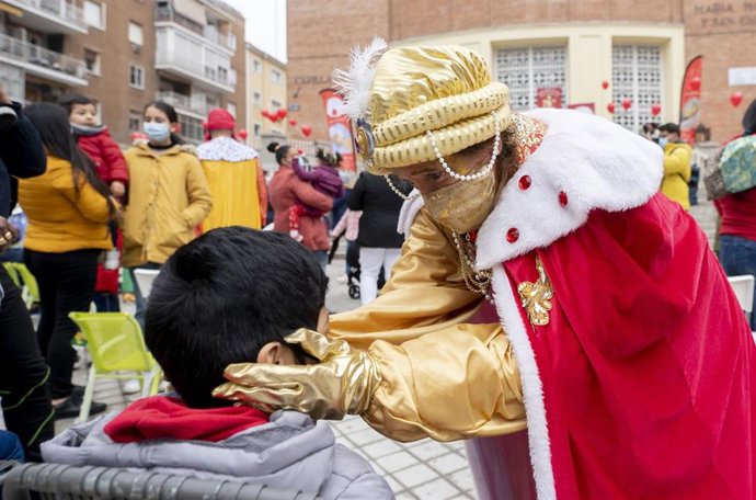Un rey saluda a un niño en el acto de la Fundación Madrina, con entrega de regalos y caramelos a niños de familias vulnerables.