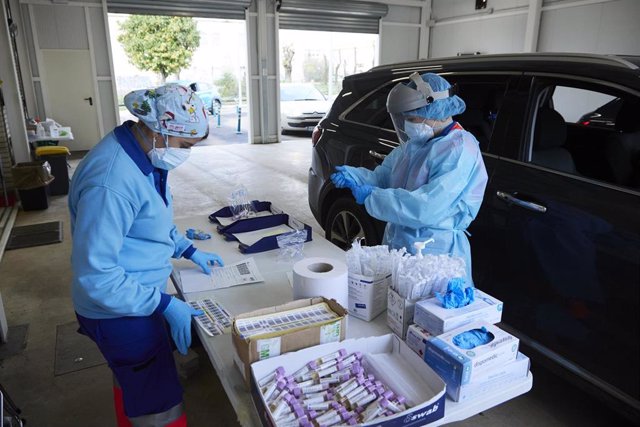Dos enfermeras preparan el test en una mesa durante la realización de PCR en el autocovid instalado en el Hospital Militar de Sevilla, foto de archivo